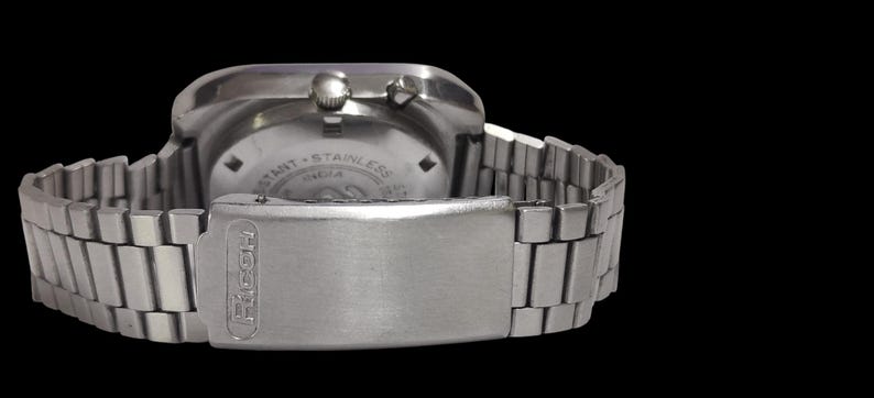 Pu&ograve; includere: Un orologio da polso in acciaio inossidabile argentato con cinturino e chiusura in metallo. Il quadrante dell'orologio &egrave; visibile, con la scritta "RESISTANT - STAINLESS INDIA". La chiusura &egrave; incisa con il nome "FACOH".