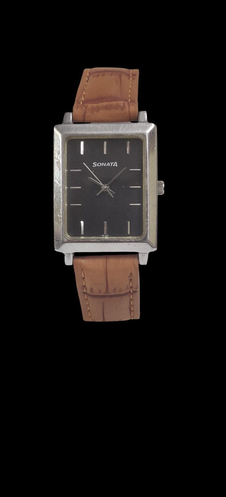 Puede incluir: Un reloj Sonata rectangular con esfera negra y caja plateada. El reloj tiene una correa de cuero marr&oacute;n. La esfera del reloj tiene marcadores de hora plateados y el nombre de la marca "Sonata" en blanco.