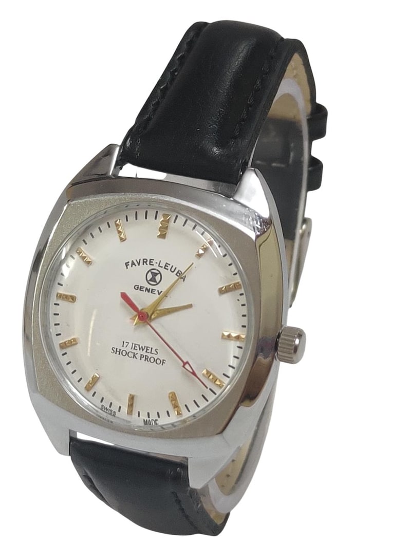 May include: A silver Favre-Leuba Geneve watch with a white face, gold hands, and a red second hand. The watch has a black leather strap and the text "17 Jewels Shock Proof". The watch is a vintage style.