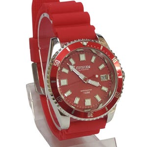 Peut inclure: Montre Citizen Automatic rouge avec bracelet en caoutchouc rouge assorti. Le cadran rouge comporte des aiguilles et des index luminescents, un guichet de date et une lunette argentée. Résistante à l'eau jusqu'à 150M.