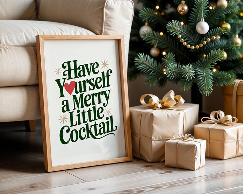 May include: A framed print with the text "Have Yourself a Merry Little Cocktail" in green and red. The print is propped against a beige sofa and a Christmas tree with wrapped gifts.