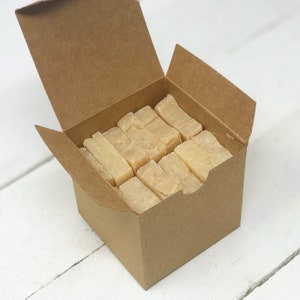 May include: A cardboard box filled with rectangular bars of soap. The box is open and the soap bars are visible inside.
