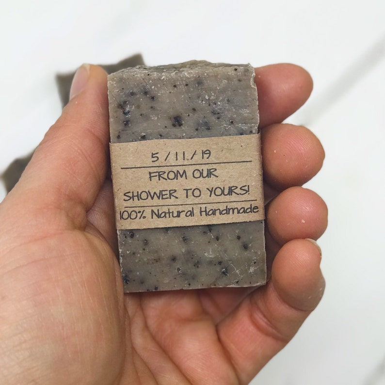 以下が含まれることがあります： 「5/11/19 From Our Shower To Yours! 100% Natural Handmade」と書かれた茶色の紙のラベルが付いた茶色の石鹸。