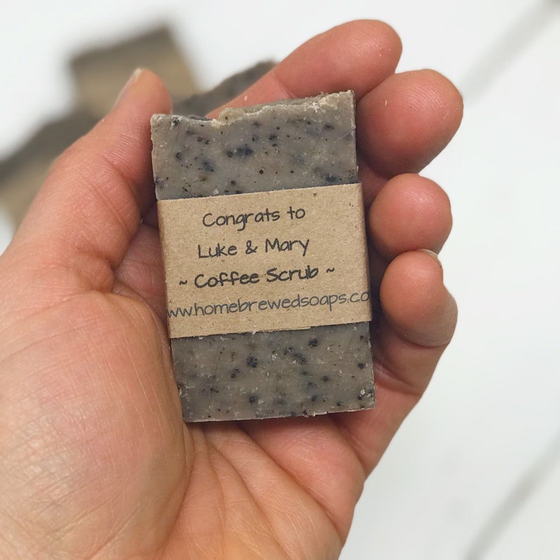 May include: A brown bar of soap with a label that reads "Congrats to Luke & Mary - Coffee Scrub - www.homebrewedsoaps.co"