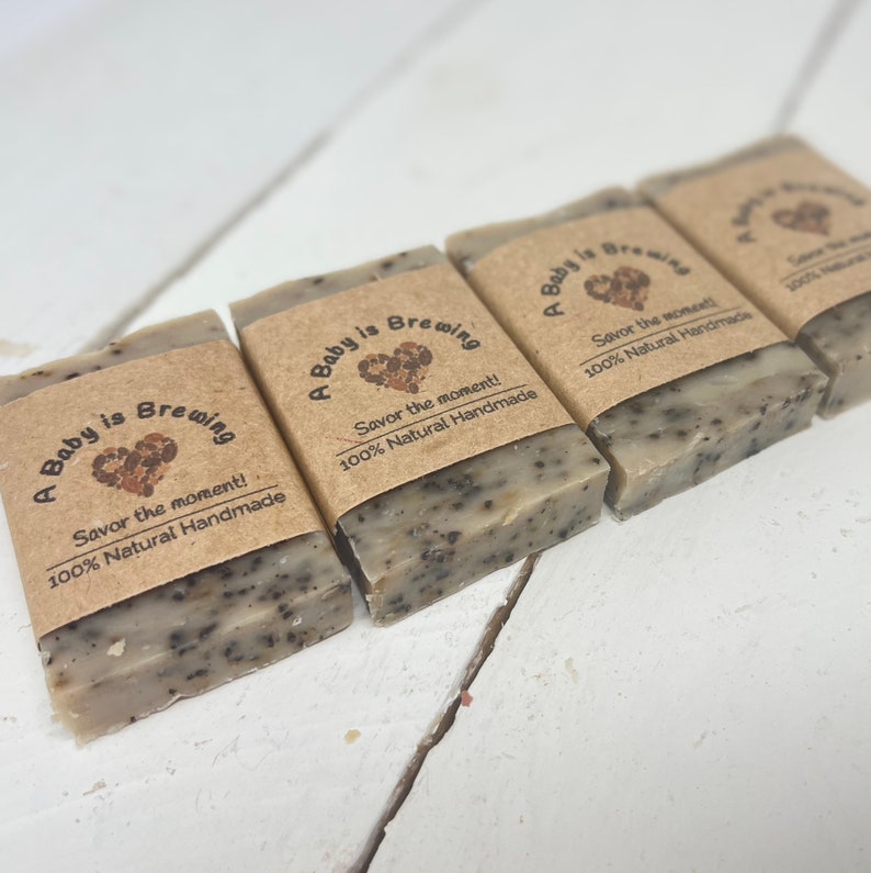 May include: Four brown paper wrapped bars of soap with the text "A Baby is Brewing" and a heart design. The text "Savor the moment! 100% Natural Handmade" is also on the bars of soap.