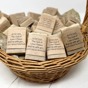May include: A wicker basket filled with handmade soap bars. Each bar is wrapped in brown paper with the text "11 Cor 13:11 The God of Love & Peace shall be with you... 100% Natural Handmade".