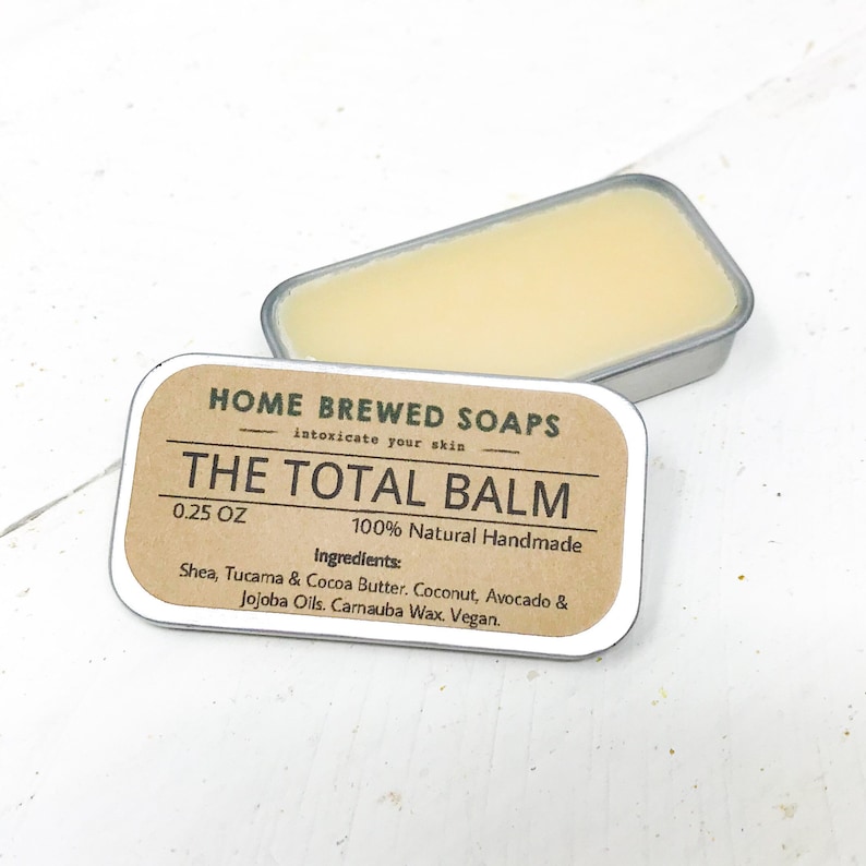 Puede incluir: Una peque&ntilde;a lata con una etiqueta marr&oacute;n que dice "HOME BREWED SOAPS intoxicate your skin THE TOTAL BALM 0.25 OZ 100% Natural Handmade Ingredients: Shea, Tucama & Cocoa Butter. Coconut, Avocado & Jojoba Oils. Carnauba Wax. Vegan."