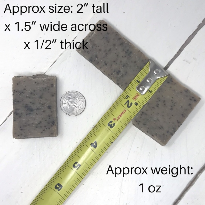May include: Two bars of speckled grey soap, one measured with a yellow tape measure. The soap is 2 inches tall, 1.5 inches wide, and 1/2 inch thick. The text reads "Approx size: 2" tall x 1.5" wide across x 1/2" thick" and "Approx weight: 1 oz".
