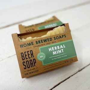 以下が含まれることがあります： 茶色の段ボール箱に入った、Herbal Mintビール石鹸が2つ。 パッケージには「Home Brewed Soaps」と「Beer Soap」と書かれています。 石鹸は自家製ビールで作られており、顔、手、体用です。 各バーの重量は99グラムです。