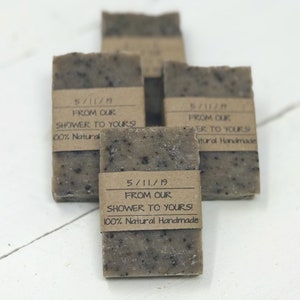 以下が含まれることがあります： 「5/11/19 From Our Shower To Yours! 100% Natural Handmade」と書かれた茶色の紙のラベルが付いた、茶色の石鹸が4つあります。