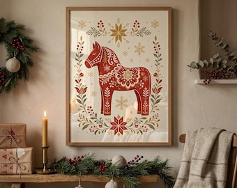 May include: A framed wall art print featuring a stylized red Dala horse centered within a decorative wreath of green leaves, red berries, and gold snowflakes. The background is a cream color, and the frame is a light-toned wood finish.