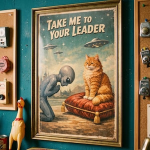 Puede incluir: Impresión vintage enmarcada con el texto "TAKE ME TO YOUR LEADER". La obra de arte representa a un extraterrestre arrodillado ante un gato naranja esponjoso sobre un cojín rojo, con ovnis en el cielo. La impresión está en un marco dorado.