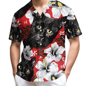 May include: Short-sleeved red Hawaiian shirt featuring a repeating pattern of black cat faces and white hibiscus flowers. The shirt has a classic collar and button-down front. The cat's eyes are yellow.