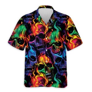May include: Short-sleeved button-down shirt featuring a vibrant pattern of colorful skulls with flames. The skulls are in shades of purple, green, yellow, and red, creating a bold and eye-catching design. The shirt has a classic collar and button closure.
