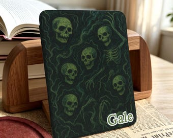 May include: A rectangular e-reader case featuring a dark green background with a repeating pattern of skulls and swirling smoke-like lines. The name Gale is printed in white letters with a green outline in the bottom right corner of the case.