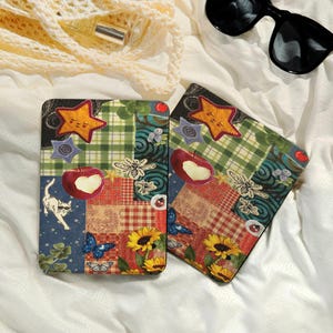 以下が含まれることがあります： パッチワークデザインの装飾的な正方形のコースター2枚。各コースターには、星、リンゴ、蜂、蝶のモチーフが描かれています。コースターは、赤、緑、青など、さまざまな色のチェック柄、花柄、無地のパターンが混在しています。