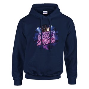 Op de afbeelding: Marineblauwe hoodie met een grafische print op de voorkant. De print toont een kroon en de woorden "MODO REINA ACTIVADO" in een cirkelvormig ontwerp met paarse en blauwe tinten. De hoodie heeft een capuchon met trekkoord en een voorzak.