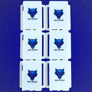 May include: Six white rectangular objects with a blue wolf head logo and the text "WOLF MOTION" are arranged in a grid against a blue background. The wolf head is a detailed illustration.