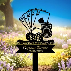 Puede incluir: Estaca de jardín de metal negro con elementos de póquer. Incluye naipes, dados y fichas. El texto dice "IN LOVING MEMORY OF Custom Name 1968-2025". Ubicado en un jardín con flores y cielo azul.