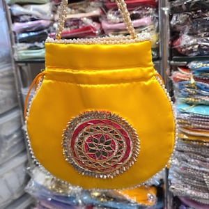 May include: A white ceramic mug with a black handle and the text "But First, Coffee" in a bold, black font. The mug is set against a blurred background, highlighting its clean design.