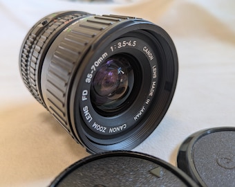 Nowy obiektyw Canon FD 35-70 mm F3.5-4.5 z zoomem makro z lat 80. z przednią i tylną pokrywką obiektywu