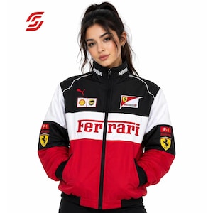 May include: A black, white, and red Ferrari jacket with the Ferrari logo across the chest. The jacket has a stand-up collar and a full-length zipper. The sleeves are black and red, with the Ferrari logo on the left sleeve.
