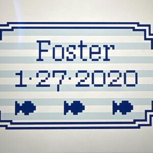 May include: A rectangular sign with a blue and white striped background. The word "Foster" is displayed in blue block letters, along with the date "1.27.2020". Three blue fish icons are at the bottom.
