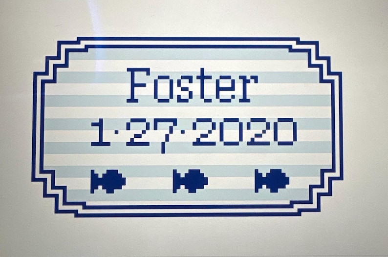 May include: A rectangular sign with a blue and white striped background. The word "Foster" is displayed in blue block letters, along with the date "1.27.2020". Three blue fish icons are at the bottom.