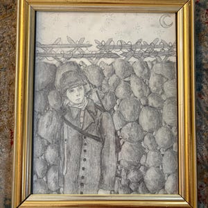 Op de afbeelding: Potloodtekening in een gouden lijst. Het kunstwerk toont een persoon in een jas en hoed in militaire stijl, staand voor een stenen muur en een prikkeldraadomheining onder een nachthemel met sterren en een halve maan.