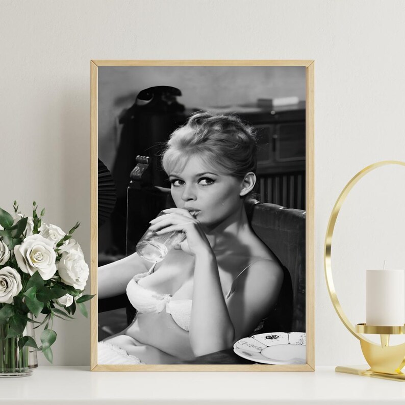 Puede incluir: Impresi&oacute;n enmarcada en blanco y negro que muestra a una mujer bebiendo de un vaso. La mujer lleva un sujetador blanco y est&aacute; sentada en una silla. Un plato con un dise&ntilde;o est&aacute; sobre una mesa. La impresi&oacute;n est&aacute; en un marco de madera.