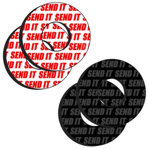 May include: Two circular stickers with the phrase "SEND IT" repeated. One set is red text on a white background, the other is gray text on a black background. The stickers have a black outline.