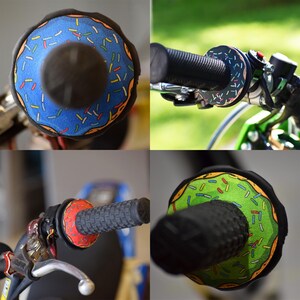 May include: Motorcycle handlebar grips with a unique donut design. The grips feature a blue, green, and red donut pattern with colorful sprinkles. The grips are shown on a motorcycle, with close-up shots of the grips and handlebars.