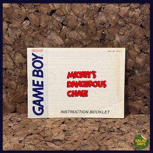 May include: A vintage Game Boy instruction booklet for "Mickey's Dangerous Chase." The cover is white with the Game Boy logo in blue and the game title in red. The booklet is labeled "Instruction Booklet."