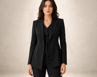 May include: A black three-piece suit featuring a double-breasted blazer with notched lapels, a button-front vest, and matching trousers. The garment displays the LOOMENZA logo in the upper left corner. The ensemble is solid black throughout.