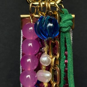 Detailed view of upper part with bright blue bead, pink faceted beads, and glossy white pearls on gold chain.