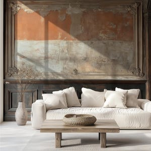 May include: A white sofa with four white throw pillows sits before a low wooden coffee table holding a woven bowl. To the left, a tall vase contains dried branches. The wall features dark wood paneling and a large, weathered orange mural.