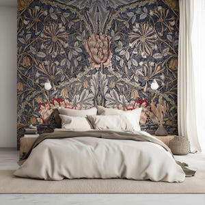 Puede incluir: Dormitorio con un gran papel pintado floral en tonos azul marino, beige y rojo. La cama tiene un edredón y almohadas beige. Una mesita de noche de madera, un jarrón con plantas secas y una cesta de mimbre completan la escena.