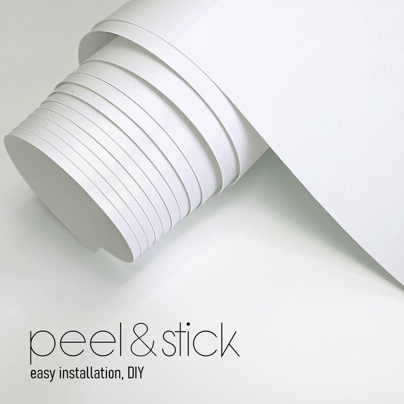 May include: A roll of white peel and stick wallpaper. The roll is partially unrolled, showing the layers of paper. The text "peel & stick" and "easy installation, DIY" are printed in black at the bottom of the image.