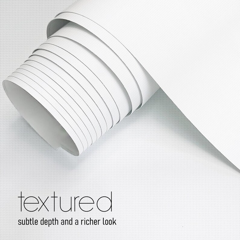 May include: A roll of white textured material with subtle depth and a richer look. The material is tightly rolled, revealing the edges of each layer. The word "textured" is displayed in a modern font.