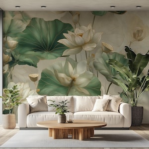 May include: A wall mural featuring large white lotus flowers and broad green leaves against a neutral background, positioned behind a cream-coloured sofa, a round wooden coffee table, and two potted plants in woven and dark textured planters.