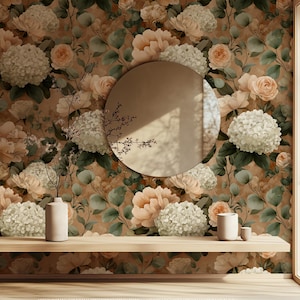 May include: A room interior featuring a floral wallpaper with large, light-colored flowers and green foliage. A round mirror is centered on the wall. A wooden shelf holds a vase, a candle, and a small cup. The overall aesthetic is soft and inviting.