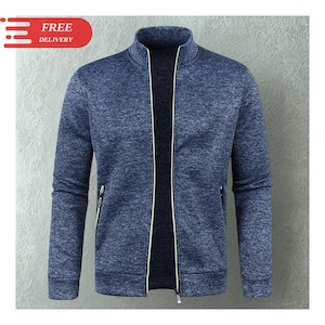 May include: A blue zip-up jacket with a stand-up collar. The jacket has a textured appearance and features a full-length zipper. The zipper and pocket zippers have a yellow accent. The jacket is a casual outerwear garment.