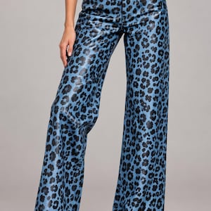 Puede incluir: Pantalones de tiro alto y pernera ancha con acabado azul brillante y estampado de leopardo negro. Estos pantalones incluyen cierre de botón y cremallera, cinco bolsillos y un diseño de corte recto que llega hasta los tobillos.