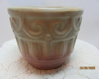 May include: A beige ceramic bowl with an embossed pattern. The bowl has a rounded shape with a slightly flared rim and a two-tone colour scheme, transitioning from beige to a pinkish hue at the base. The bowl is likely for decorative or functional use.