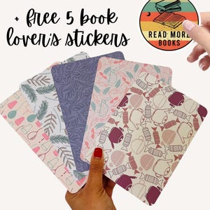 May include: Five patterned stickers with botanical and candy designs are held in a hand. A round sticker with the text "READ MORE BOOKS" and a stack of books is held in the background. The text "+ free 5 book lover's stickers" is at the top.