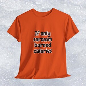 Focus on the humorous typography on an inclusive graphic t-shirt. It displays the quote "If only sarcasm burned calories" in a relaxed, bubbly font. This inspiring and funny clothing is a top-performing target for a gift for gym rats and sarcastic friends.