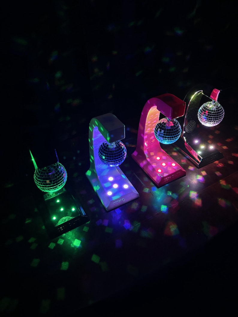 Puede incluir: Cuatro l&aacute;mparas de bola de discoteca con bases y arcos de colores. Las bolas de discoteca espejadas reflejan la luz. Las bases son blancas, rosas y negras. Los arcos coinciden con el color de la base. Luces de colores.