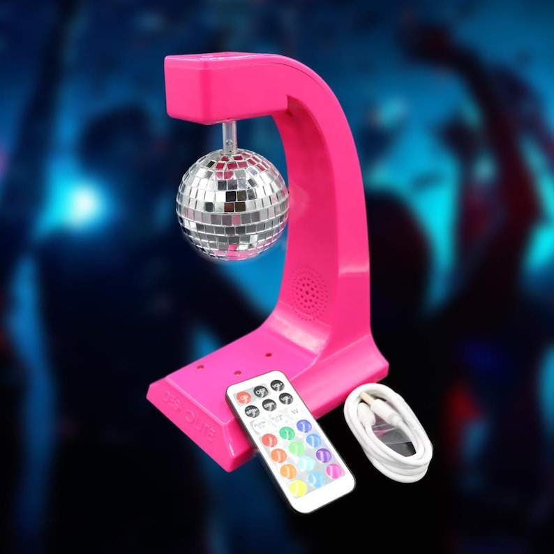 Puede incluir: Una l&aacute;mpara de bola de discoteca rosa brillante con una esfera espejada suspendida de un soporte arqueado. Se incluye un mando a distancia y un cable USB blanco. Ideal para fiestas y eventos.