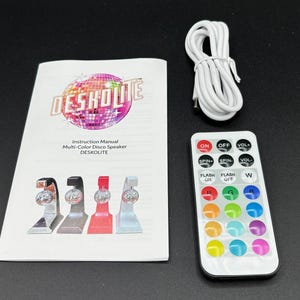 Puede incluir: Un conjunto de altavoz de discoteca multicolor con un mando a distancia, un manual de instrucciones y un cable USB blanco. El manual de instrucciones presenta el texto "DESKOLITE" y "Multi-Color Disco Speaker". El mando tiene botones.