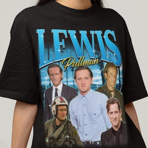 Puede incluir: Camiseta negra con un diseño gráfico azul con el nombre "LEWIS" y el nombre "Pullman" debajo. El diseño incluye imágenes de varias personas. La camiseta la lleva una persona.
